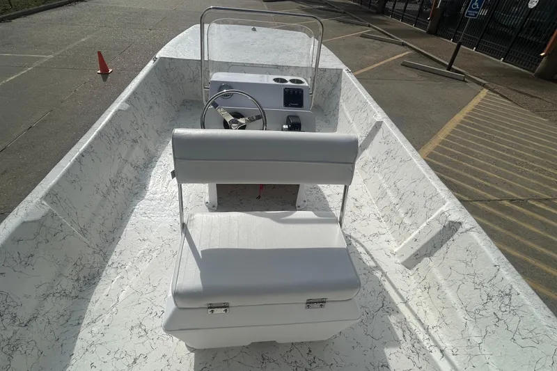Slide: The Image of 2026 Coastal Skiff 184 boat interior with white seating and steering console. - 14