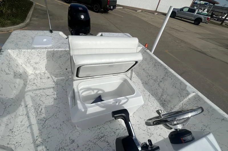 Slide: The Image of 2026 Coastal Skiff 184 boat interior with open storage compartment and steering wheel. - 16
