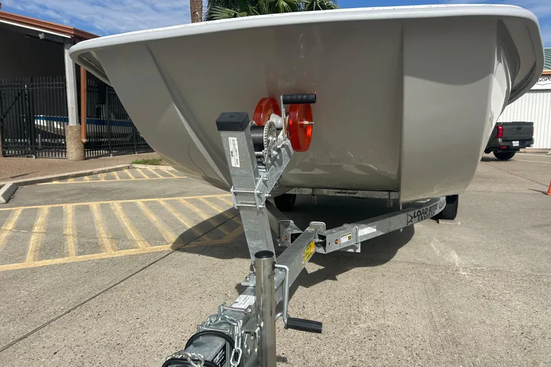 Slide: The Image of 2026 Coastal Skiff 184 boat on trailer, parked outdoors in sunny weather. - 5