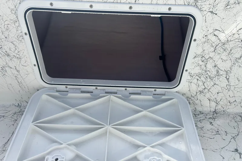 Slide: The Image of Open hatch on 2026 Coastal Skiff 184 boat, showing interior compartment. - 8