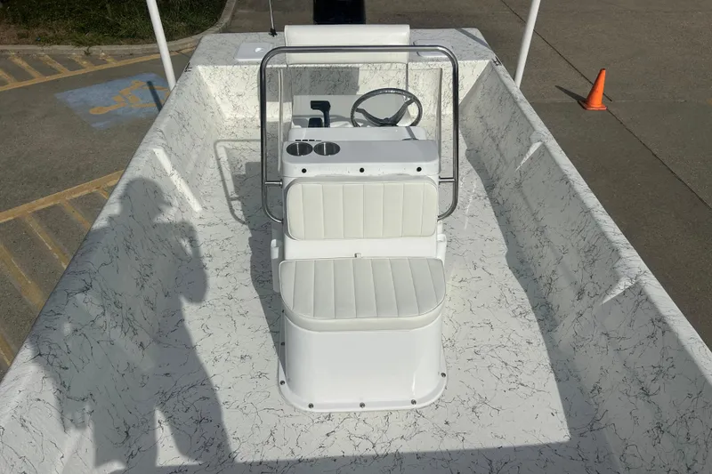 Slide: The Image of 2026 Coastal Skiff 184 boat interior with white seating and steering console. - 9