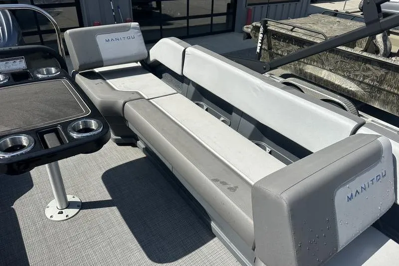 Slide: The Image of 2024 Manitou 24 X-Plode Cruise SHP boat interior with seating and cup holders. - 3