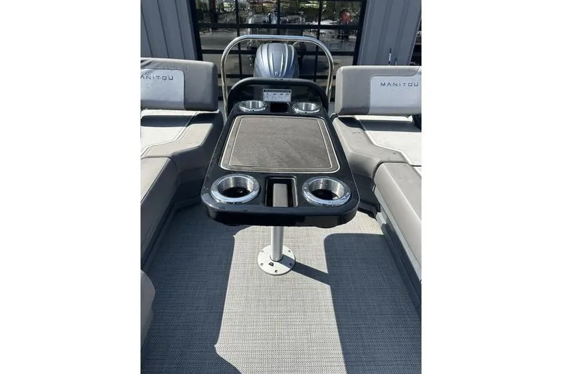 Slide: The Image of 2024 Manitou 24 X-Plode Cruise SHP boat interior with seating and table. - 4