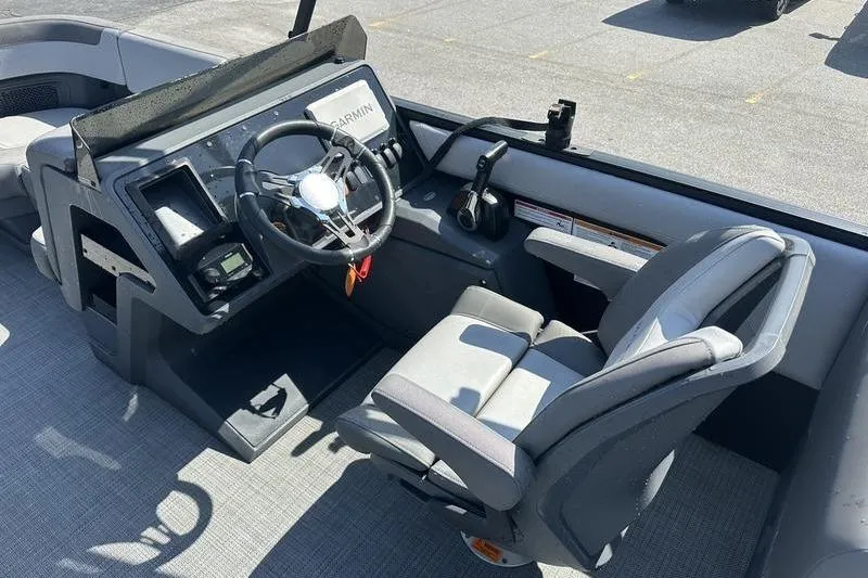 Slide: The Image of 2024 Manitou 24 X-Plode Cruise SHP boat cockpit with steering wheel and captain's chair. - 9