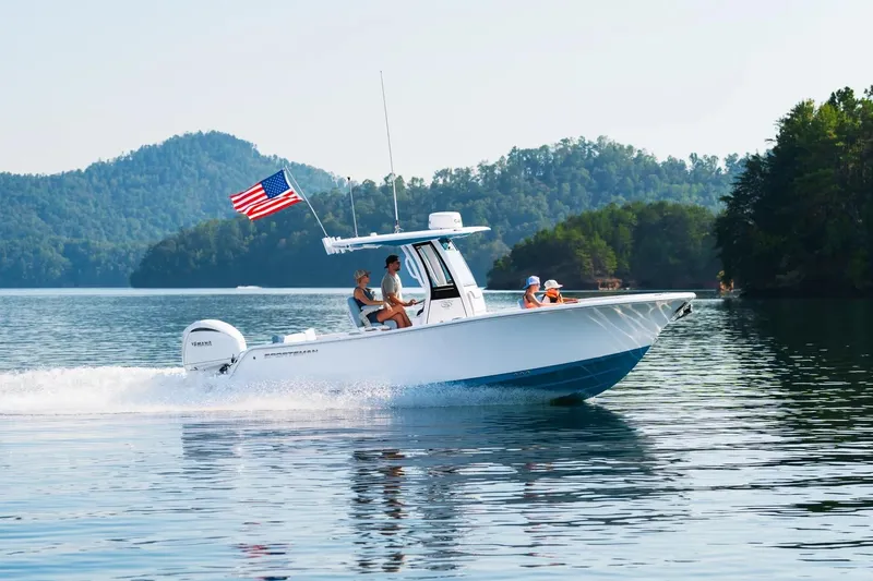 The Image of 2026 Sportsman Heritage 231 Center Console boat cruising on a scenic lake. - 1