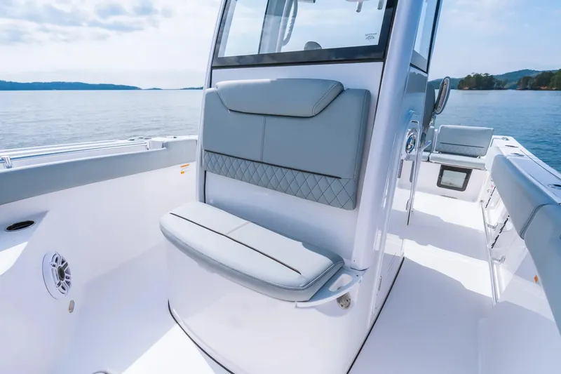 Slide: The Image of 2026 Sportsman Heritage 231 Center Console boat interior with seating, on a calm lake. - 5