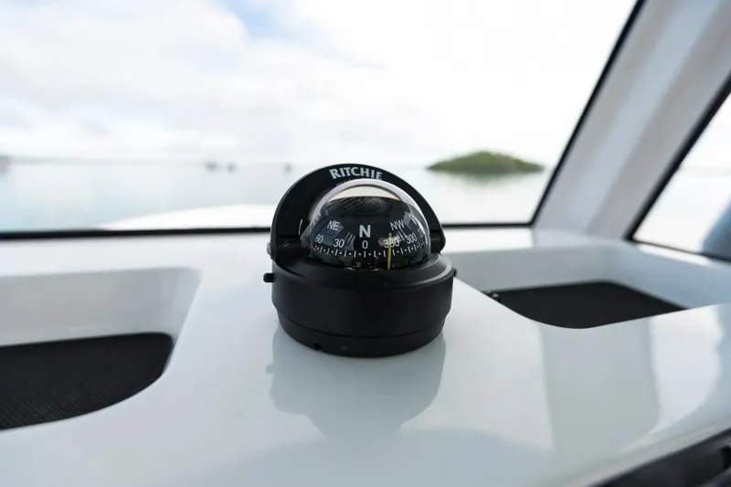 Slide: The Image of Compass on Sportsman Heritage 231 Center Console boat, 2026 model, with scenic water view. - 9