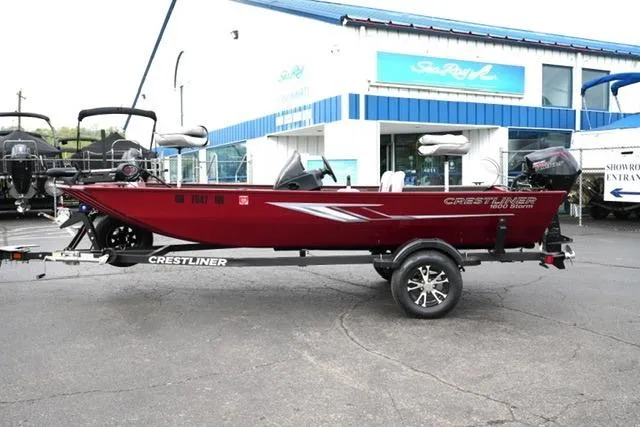 The Image of 2024 Crestliner 1600 Storm boat in vibrant red, parked outside a dealership. - 1
