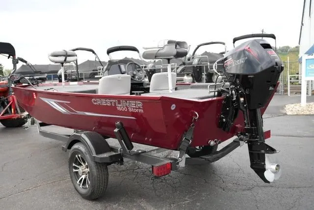Slide: The Image of 2024 Crestliner 1600 Storm boat with outboard motor on trailer, parked outdoors. - 7