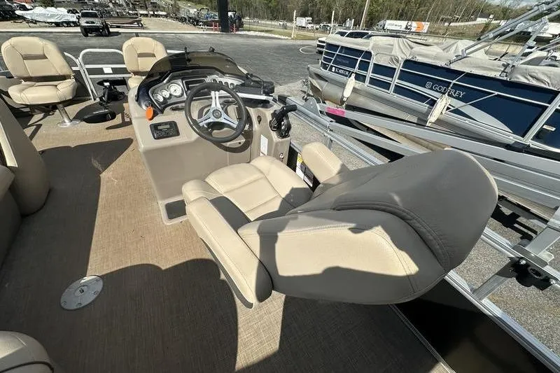 Slide: The Image of 2023 Sun Tracker Fishin' Barge 21 interior with steering console and seating. - 8