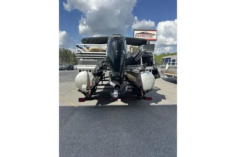 Slide: The Image of 2023 Sun Tracker Fishin' Barge 21 pontoon boat, rear view, parked outdoors. - 9