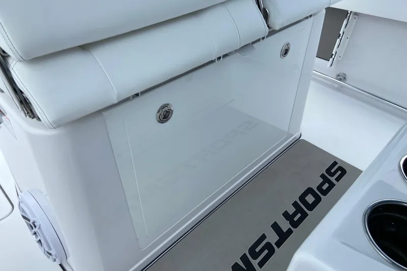 Slide: The Image of 2026 Sportsman Open 302 Center Console interior with white seating and storage compartment. - 33
