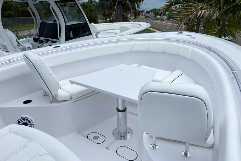 Slide: The Image of 2026 Sportsman Open 302 Center Console boat with white seating and table setup. - 38