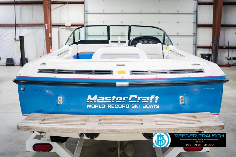 Slide: The Image of 1992 MasterCraft ProStar boat in showroom, blue and white design, on trailer. - 8