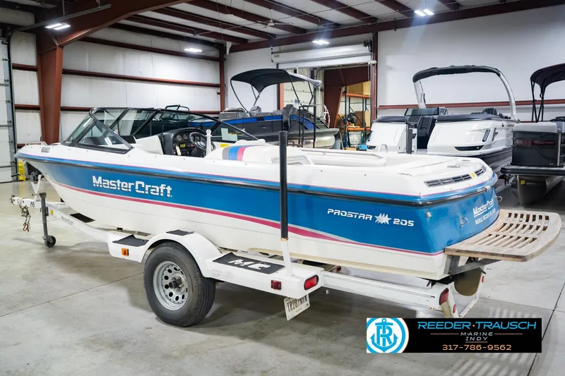 Slide: The Image of 1992 MasterCraft ProStar boat interior with white, blue, and pink seating in showroom. - 9