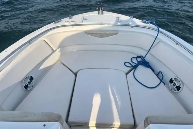 Slide: The Image of 2016 Robalo R247 Dual Console boat interior with seating and blue rope on water. - 11