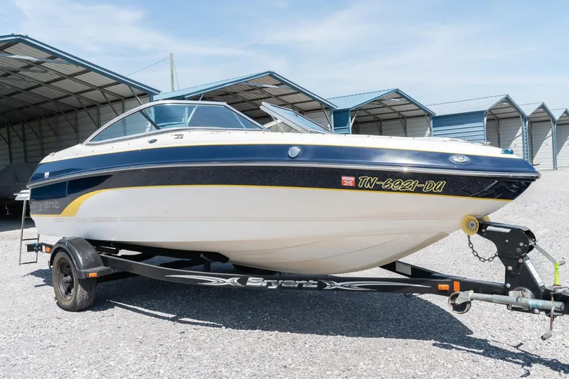 The Image of 2007 Bryant 190 boat on trailer, parked outdoors near metal shelters. - 1