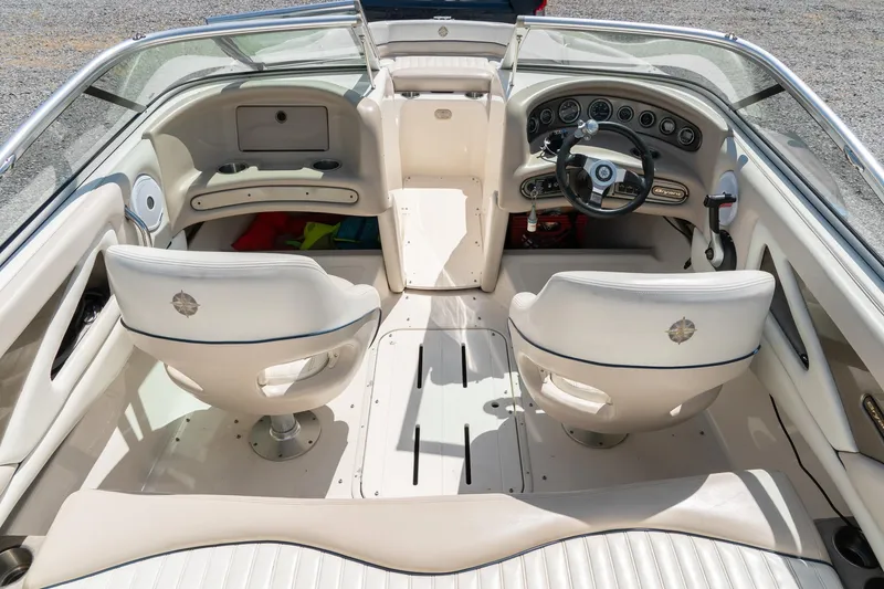 Slide: The Image of Interior of a 2007 Bryant 190 boat featuring dual captain chairs and a sleek dashboard. - 11