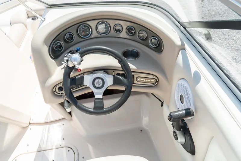 Slide: The Image of Steering wheel and dashboard of a 2007 Bryant 190 boat, featuring multiple gauges. - 14