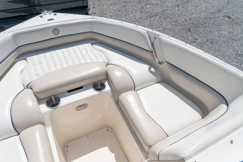 Slide: The Image of 2007 Bryant 190 boat interior with white cushioned seating and cup holders. - 17