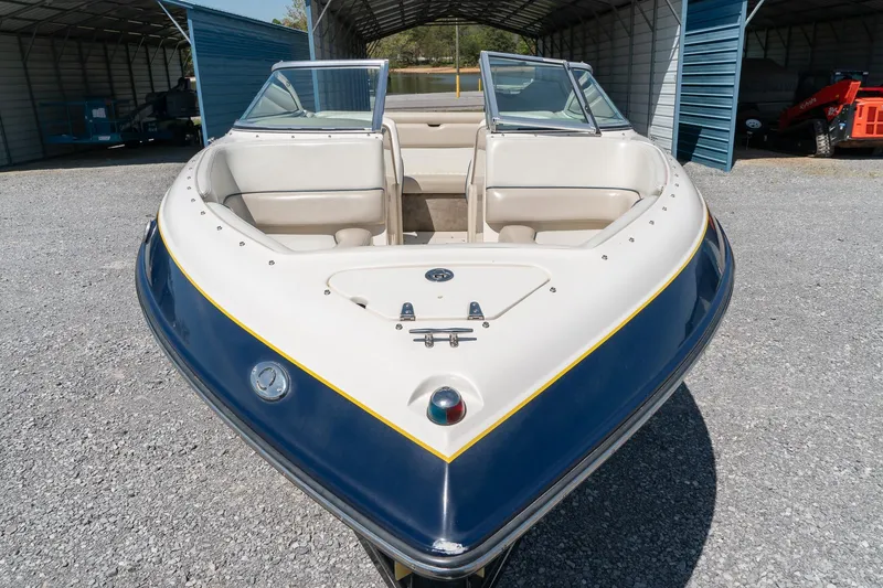 Slide: The Image of 2007 Bryant 190 boat with open bow seating, parked in a covered storage area. - 18