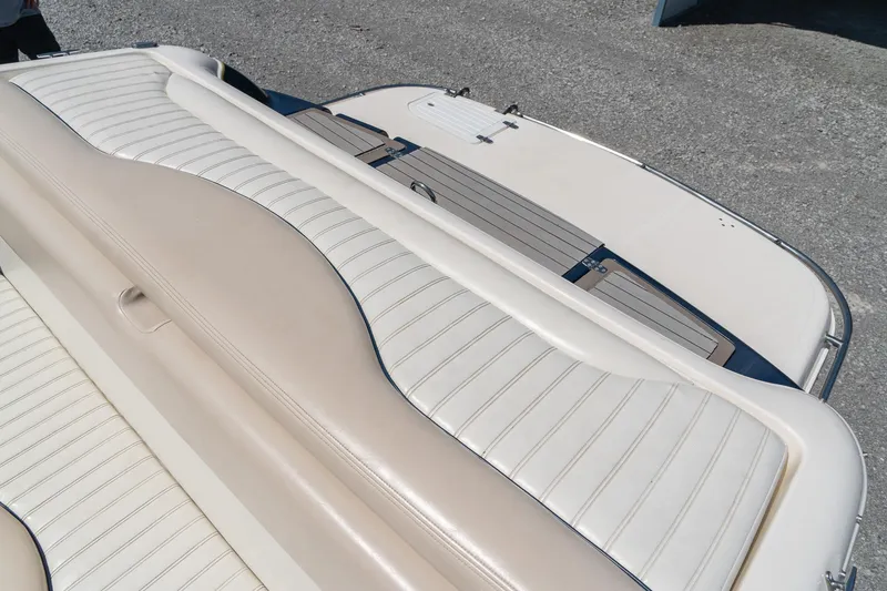Slide: The Image of 2007 Bryant 190 boat interior with beige and white seating on a sunny day. - 24