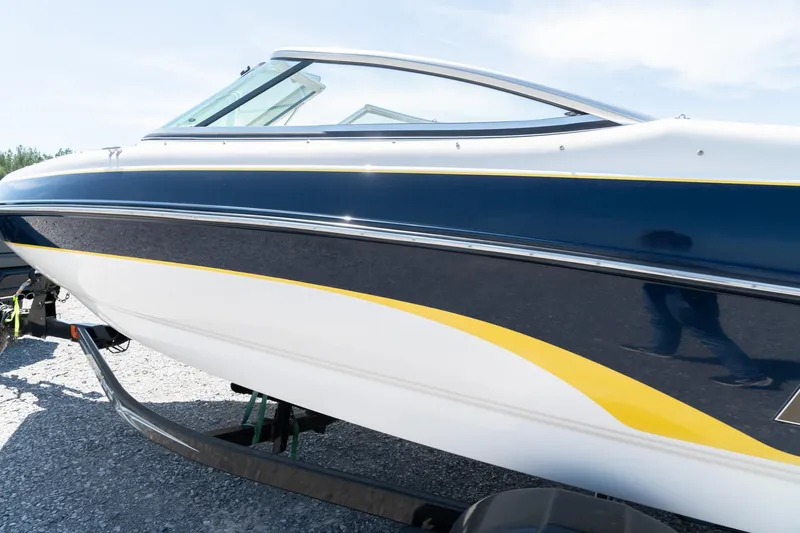 Slide: The Image of 2007 Bryant 190 boat with sleek blue and yellow design on a trailer. - 7