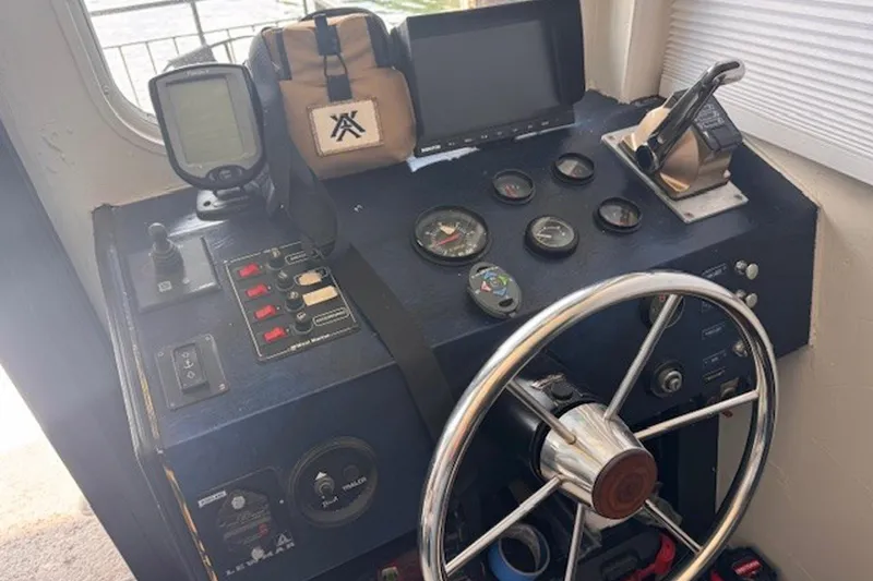 Slide: The Image of Control panel of a 1985 Three Buoys houseboat with steering wheel and navigation instruments. - 12
