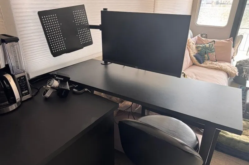 Slide: The Image of Modern workspace inside a 1985 Three Buoys houseboat with a desk, monitor, and coffee maker. - 14