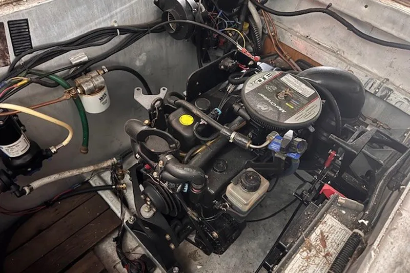 Slide: The Image of Engine compartment of a 1985 Three Buoys houseboat, showcasing mechanical components and wiring. - 22