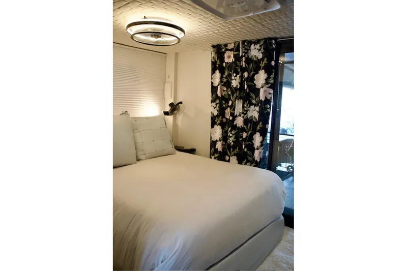 Slide: The Image of Cozy bedroom in 1985 Three Buoys houseboat with floral curtains and modern lighting. - 23