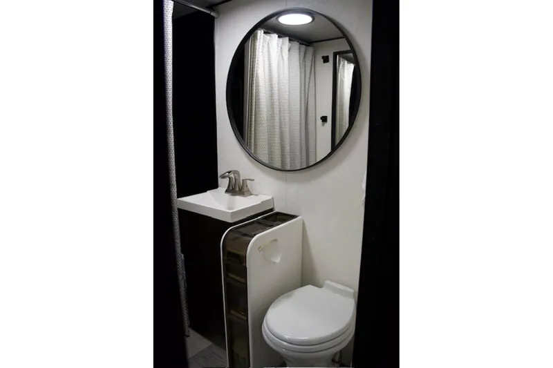 Slide: The Image of Compact bathroom in 1985 Three Buoys houseboat with round mirror and modern fixtures. - 27