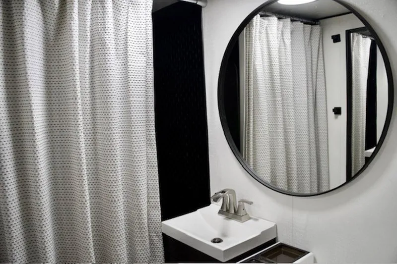 Slide: The Image of Bathroom interior of a 1985 Three Buoys houseboat with round mirror and shower curtain. - 28