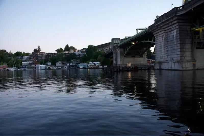 Slide: The Image of Waterfront view with bridge, houses, and a 1985 Three Buoys houseboat. - 34