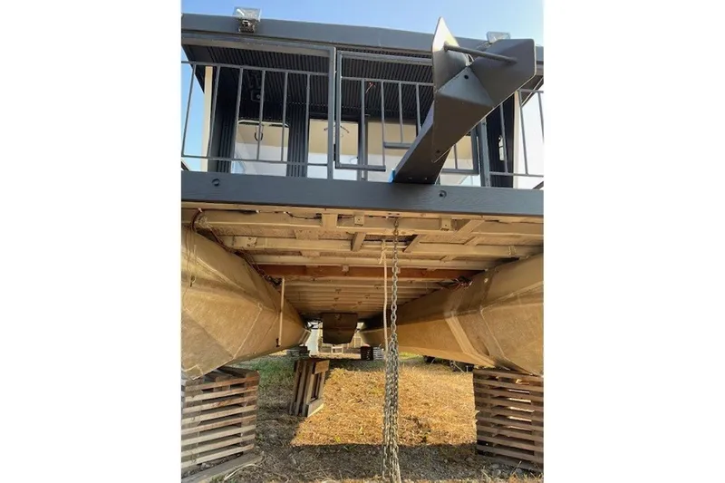 Slide: The Image of 1985 Three Buoys houseboat on blocks, showing underside and pontoons. - 5