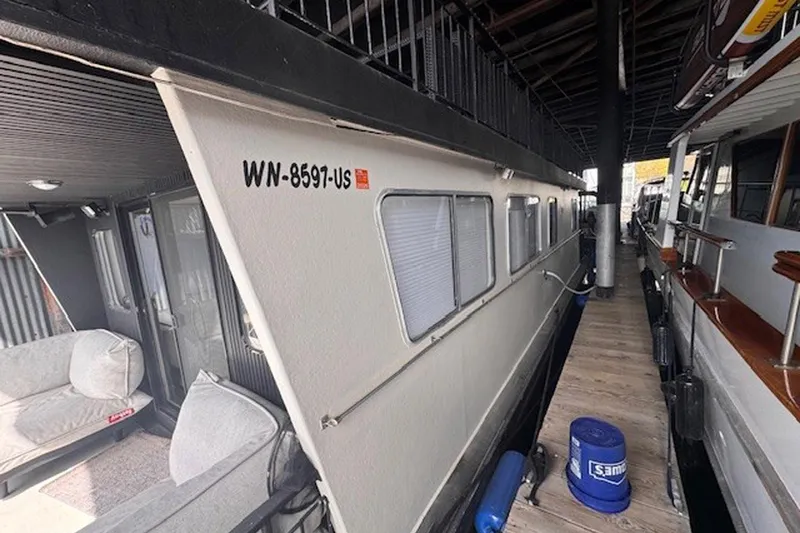 Slide: The Image of 1985 Three Buoys houseboat docked, featuring exterior view and registration number WN-8597-US. - 6