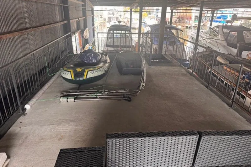 Slide: The Image of Covered marina with inflatable boats and a 1985 Three Buoys houseboat. - 7