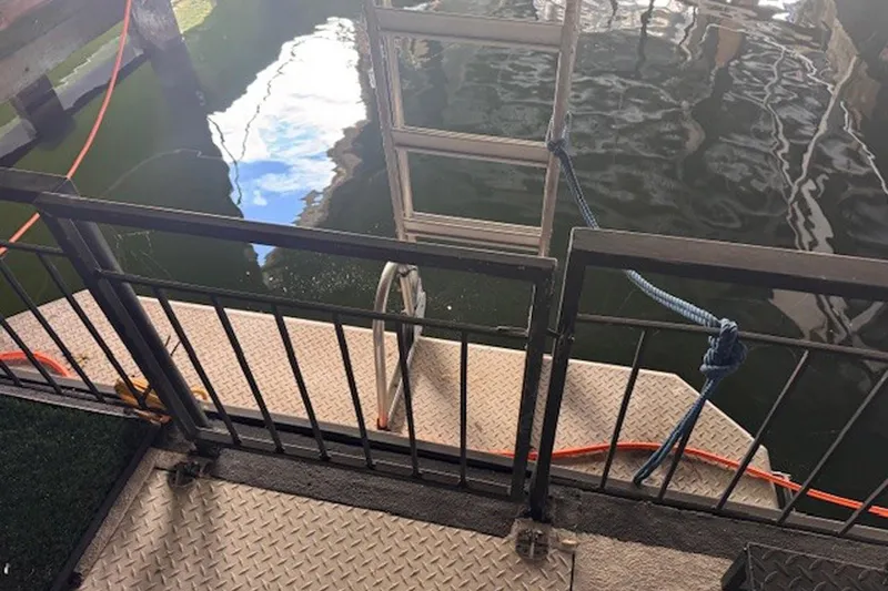 Slide: The Image of 1985 Three Buoys houseboat deck with railing and ladder over water. - 8