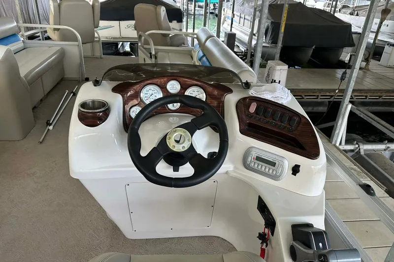 Slide: The Image of Steering console of a 2008 Landau Atlantis 250 Sport Cruise boat at a dock. - 13