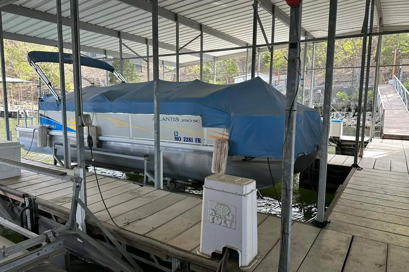 Slide: The Image of 2008 Landau Atlantis 250 Sport Cruise boat docked under a covered marina. - 19