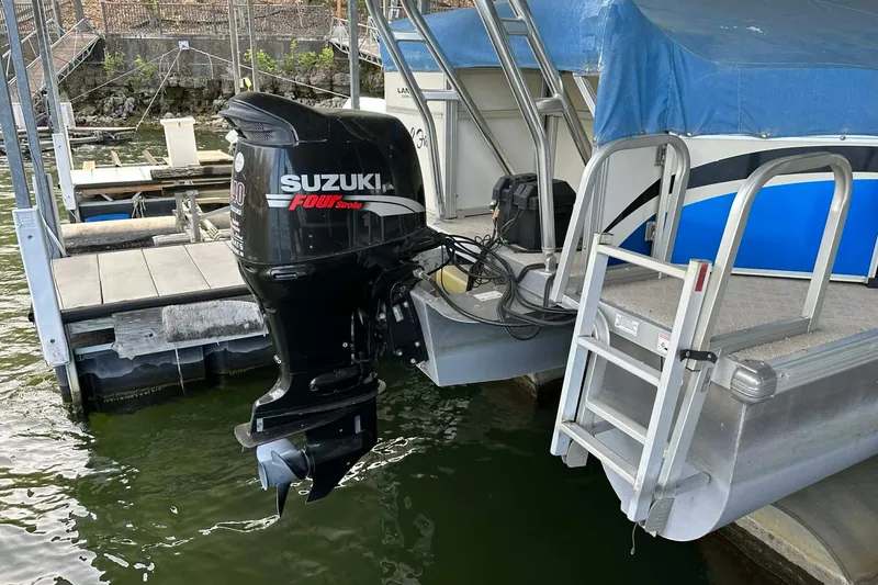 Slide: The Image of 2008 Landau Atlantis 250 Sport Cruise with Suzuki outboard motor at dock. - 2