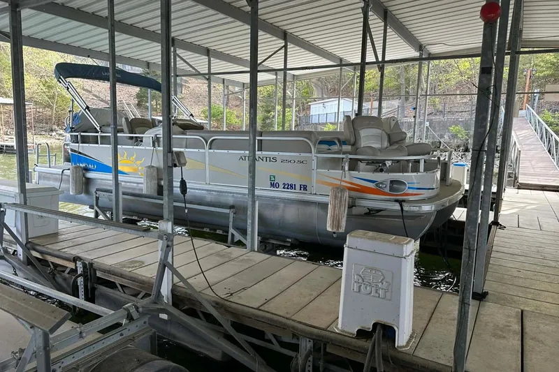 Slide: The Image of 2008 Landau Atlantis 250 Sport Cruise pontoon boat docked in a covered marina. - 22