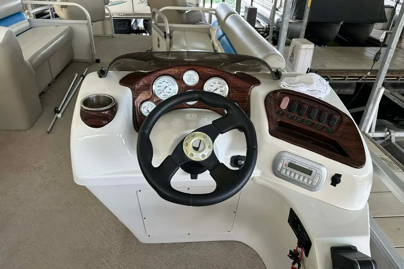 Slide: The Image of 2008 Landau Atlantis 250 Sport Cruise dashboard with steering wheel and control panel. - 3