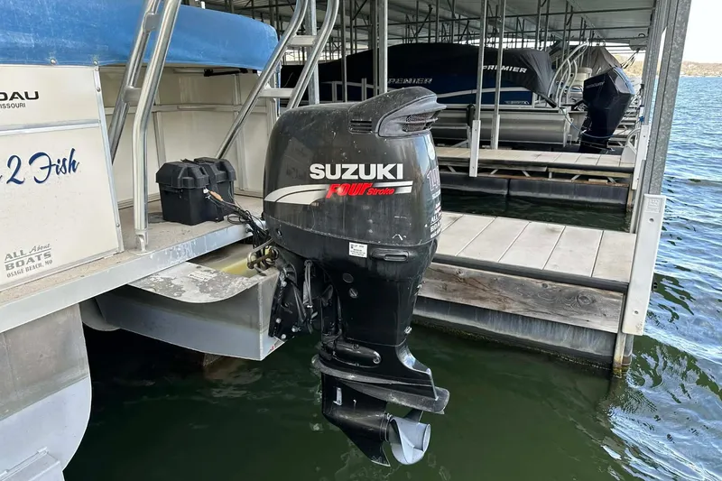 Slide: The Image of 2008 Landau Atlantis 250 Sport Cruise with Suzuki outboard motor docked at marina. - 7