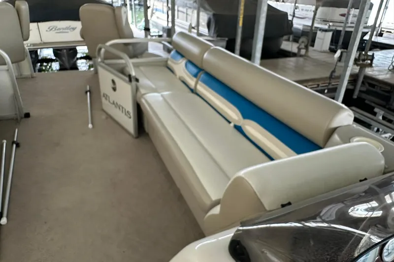 Slide: The Image of 2008 Landau Atlantis 250 Sport Cruise boat interior with beige seating and blue accents. - 9