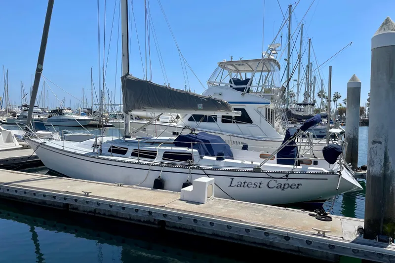 The Image of 1979 Catalina 38 sailboat named "Latest Caper" docked at a marina. - 0