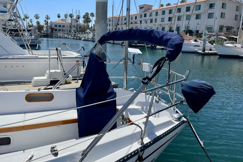 Slide: The Image of 1979 Catalina 38 sailboat docked in marina with blue covers. - 10