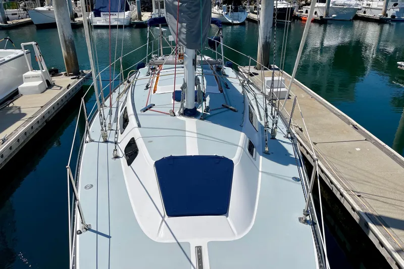 Slide: The Image of 1979 Catalina 38 sailboat docked at marina, showcasing deck and rigging. - 15
