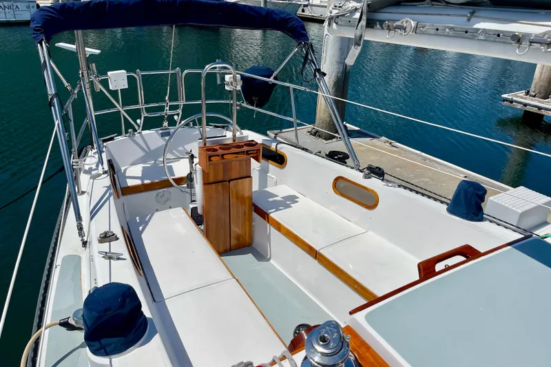 Slide: The Image of 1979 Catalina 38 sailboat cockpit with wooden accents, docked in a marina. - 16