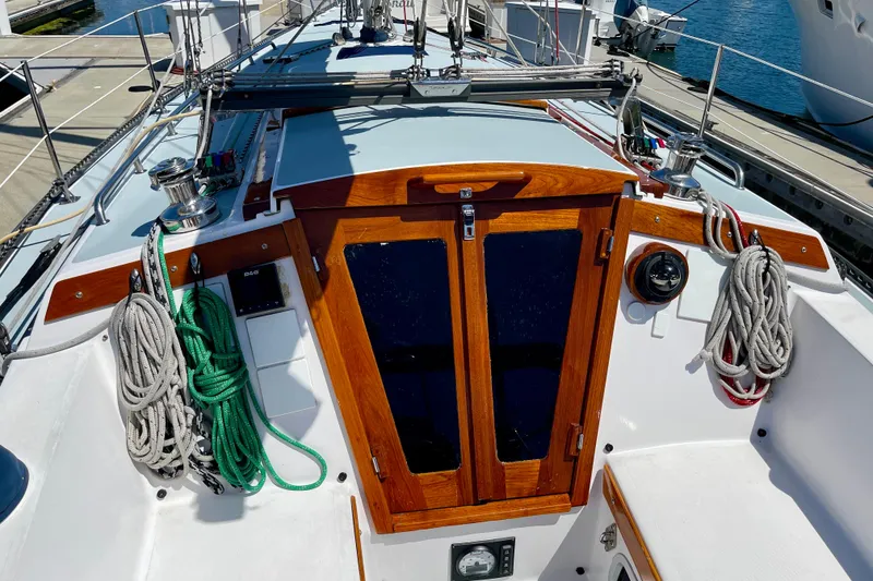 Slide: The Image of 1979 Catalina 38 sailboat cockpit with wooden hatch, ropes, and winches at dock. - 17